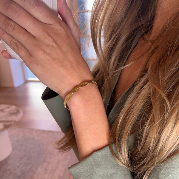 Close-up af Flad Twist Slange Armbånd med blank finish.