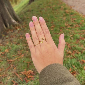Wave Ring vist i bevægelse med fokus på det organiske bølgedesign og den gyldne finish.
