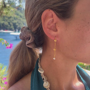 Sideprofil af Lilje Dangle Øreringe med elegant guldfinish.