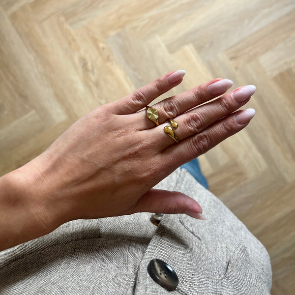 Model bærer Sun Rund Ring i 18K guldbelagt rustfrit stål.