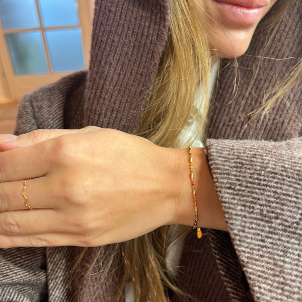 Model bærer Color Dot Armbånd i 18K guldbelagt rustfrit stål.