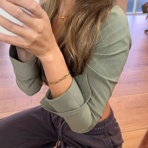 Model bærer Flad Twist Slange Armbånd i 18K guldbelagt rustfrit stål.