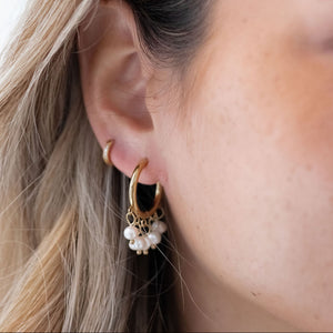 Model bærer Perle Hoops Øreringe i 18K guldbelagt rustfrit stål.