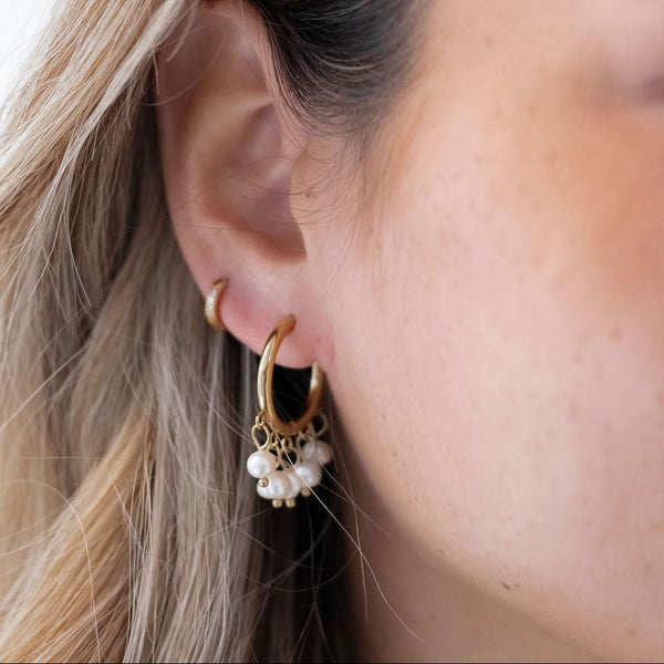 Model bærer Perle Hoops Øreringe i 18K guldbelagt rustfrit stål.