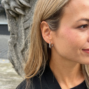 Model bærer Star Øreringe i sølvfarvet rustfrit stål.