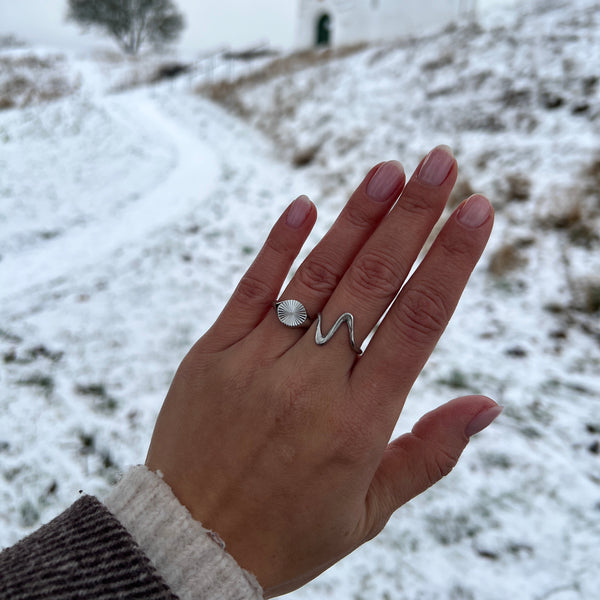 Model bærer Wave Ring i sølvfarvet rustfrit stål.